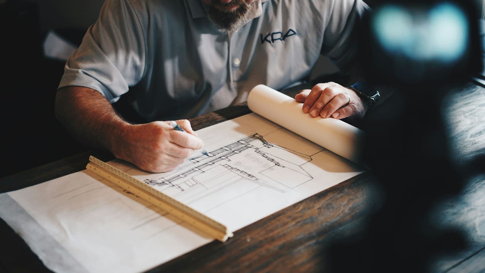 Un arquitecto dibuja un plano con regla y lápiz